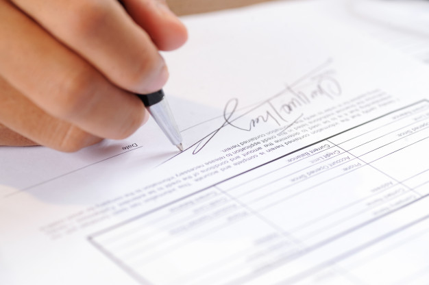 closeup-person-signing-document-with-ball-pen_1262-14867